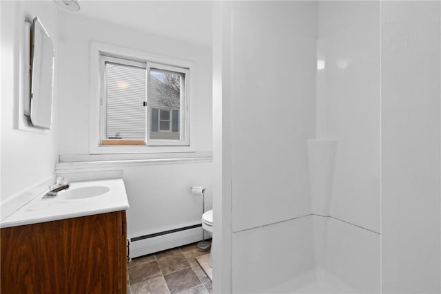 full bathroom featuring a baseboard radiator, vanity, a shower, stone finish flooring, and toilet