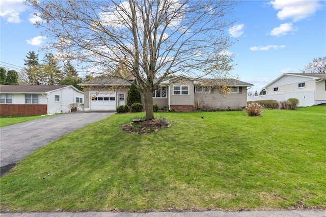ranch-style home with fence, aphalt driveway, a front yard, and a garage