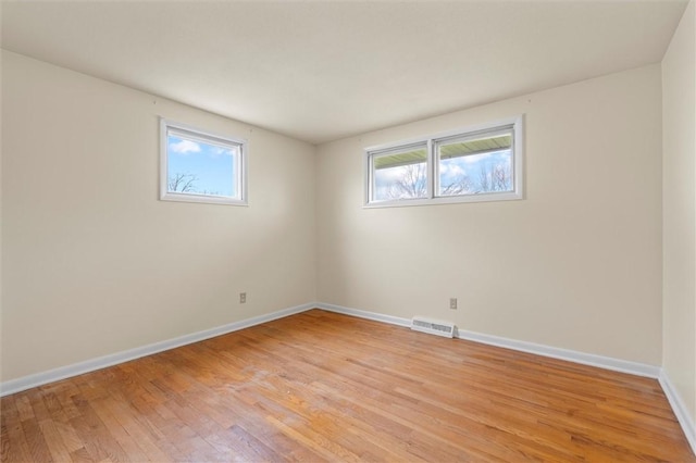 unfurnished room featuring light wood finished floors, baseboards, and visible vents