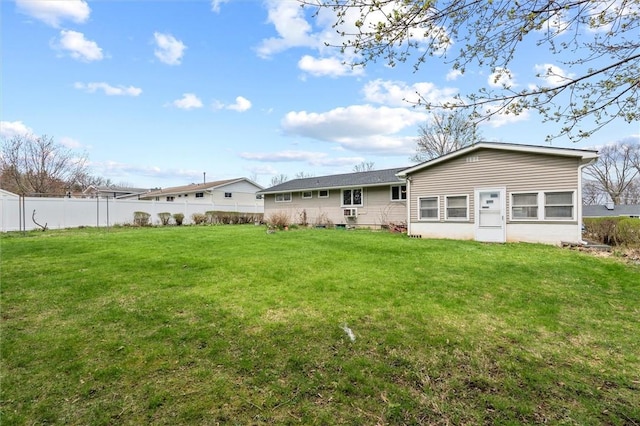 back of house featuring a lawn and fence