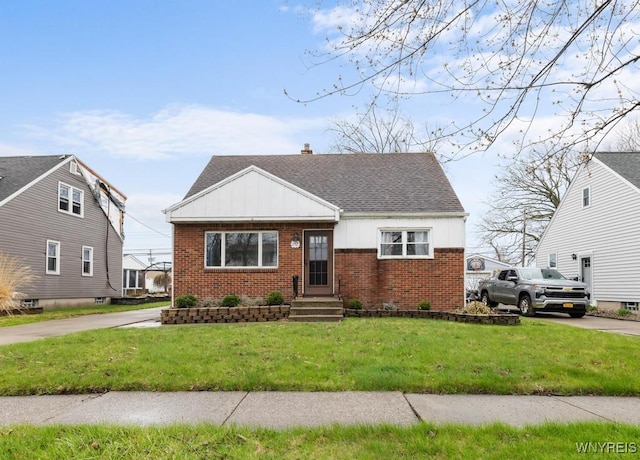 bungalow-style house featuring brick siding, roof with shingles, board and batten siding, and a front yard