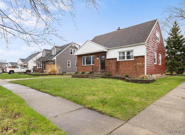 view of front of house with a front lawn, brick siding, and a shingled roof