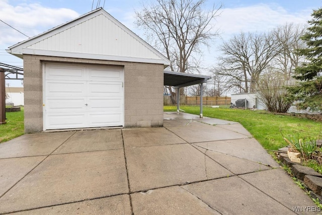 detached garage with concrete driveway and fence