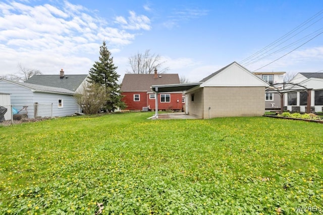 back of property with fence, a patio area, and a lawn