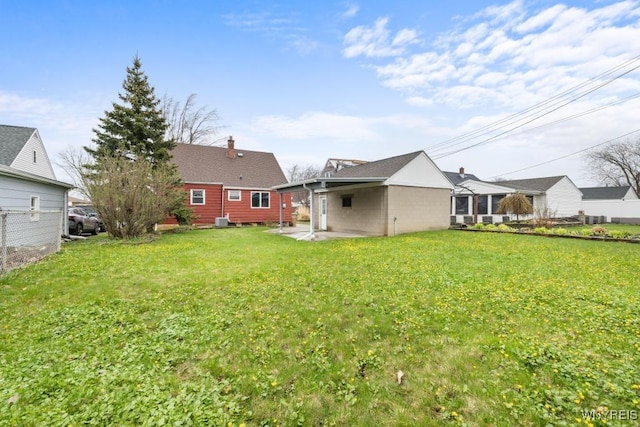 back of property with a yard, a patio area, and central AC