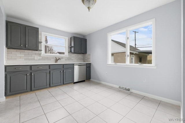 kitchen with dishwasher, light countertops, backsplash, baseboards, and visible vents