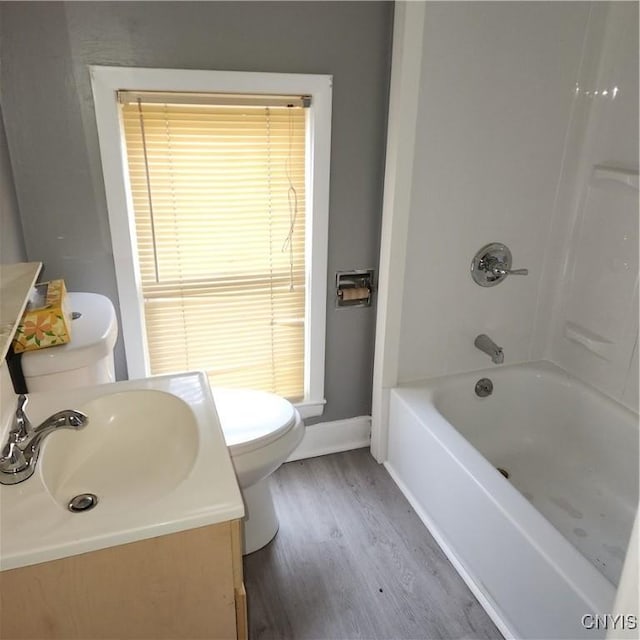 417 Otsego St, German Flatts, NY 13357 - bathroom featuring toilet, bathtub / shower combination, baseboards, wood finished floors, and vanity