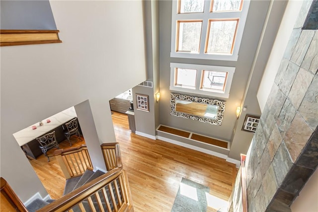 4872 Bedford Dr, Canandaigua-Town, NY 14424 - stairs featuring wood finished floors, visible vents, a towering ceiling, and baseboards