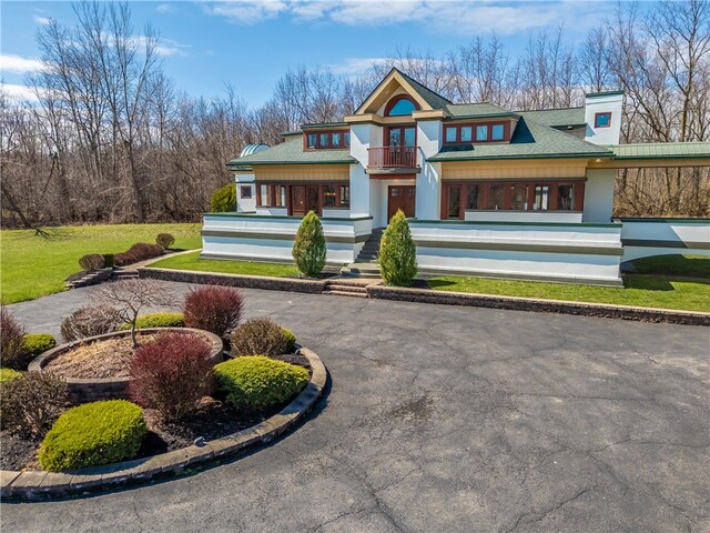 4872 Bedford Dr, Canandaigua-Town, NY 14424 - view of front facade featuring a balcony, curved driveway, stucco siding, a porch, and roof with shingles
