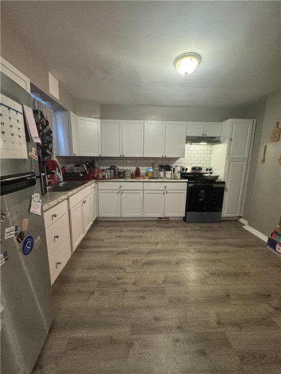 kitchen with tasteful backsplash, under cabinet range hood, stainless steel appliances, white cabinetry, and dark wood-style flooring
