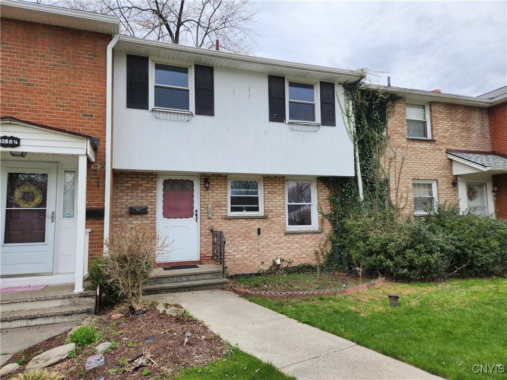 4288 Candlelight Ln, Clay, NY 13090 - townhome / multi-family property featuring a front yard, entry steps, and brick siding