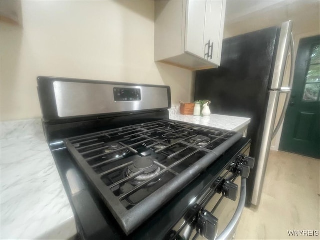 interior details with white cabinets and stainless steel gas range