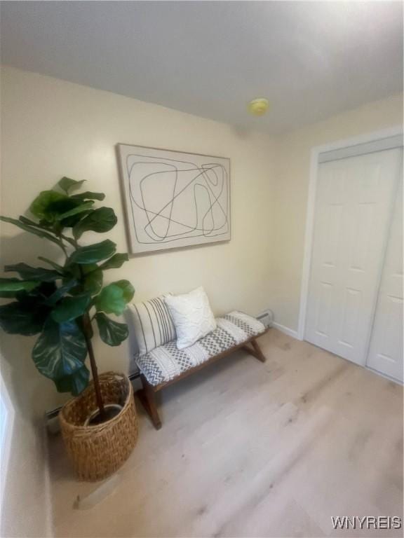 sitting room featuring baseboards and light wood finished floors