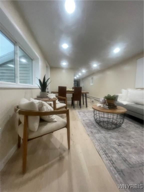 living room featuring light wood-style flooring, baseboards, and recessed lighting