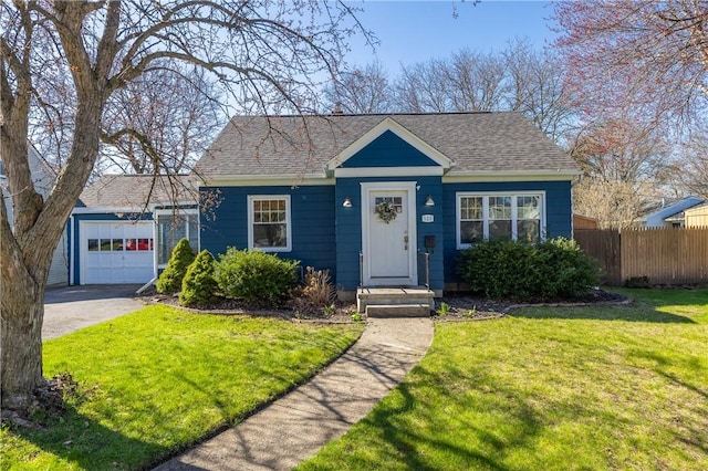 bungalow featuring fence, roof with shingles, and a front yard