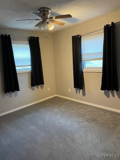 13289 Lakeview Dr, Carlton, NY 14571 - spare room with dark carpet, a textured ceiling, baseboards, and ceiling fan