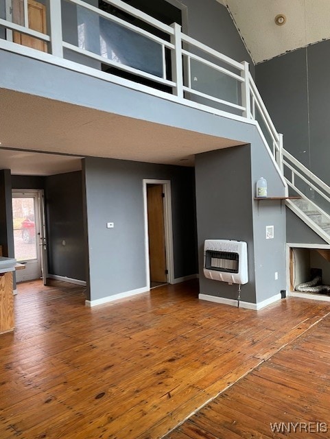 13289 Lakeview Dr, Carlton, NY 14571 - unfurnished living room with baseboards, a high ceiling, hardwood / wood-style flooring, and heating unit