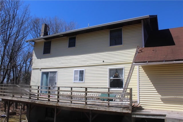back of house featuring a chimney and a deck