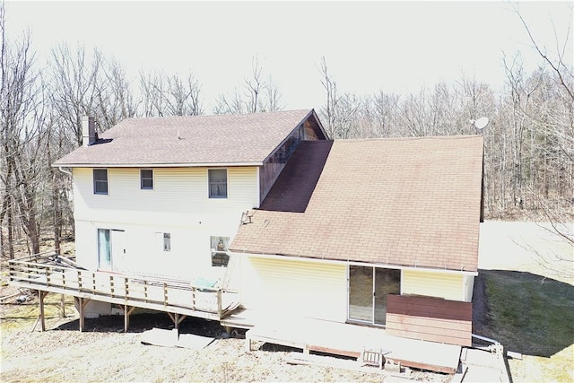 rear view of house with a chimney and a deck