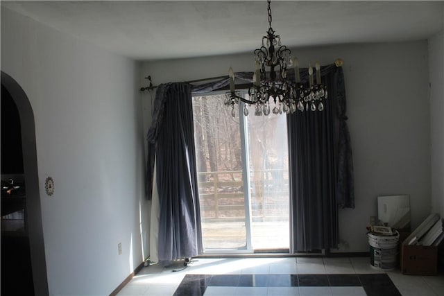 tiled dining area with arched walkways and a notable chandelier