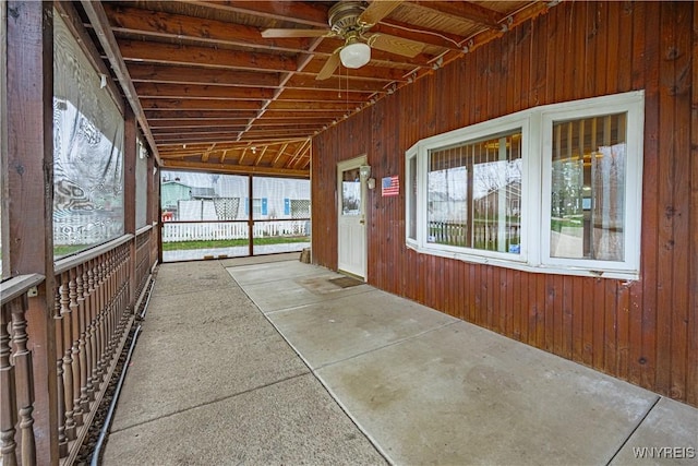 unfurnished sunroom featuring a ceiling fan