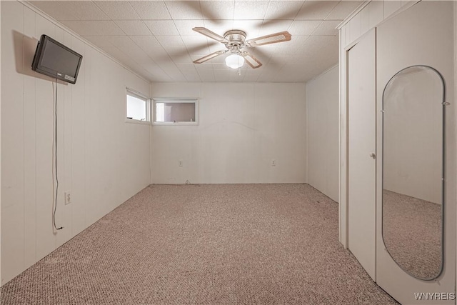 below grade area with carpet and a ceiling fan