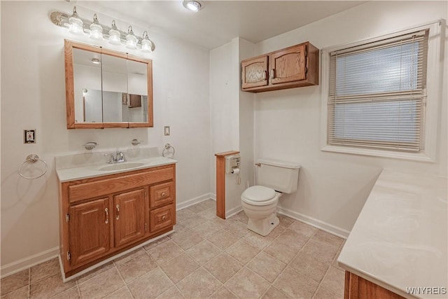 bathroom featuring vanity, toilet, and baseboards