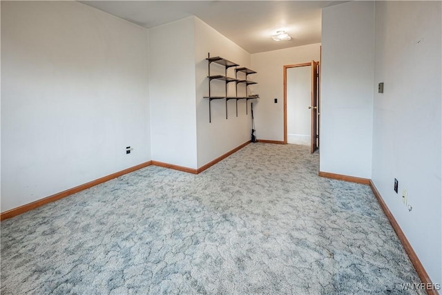 carpeted empty room featuring baseboards