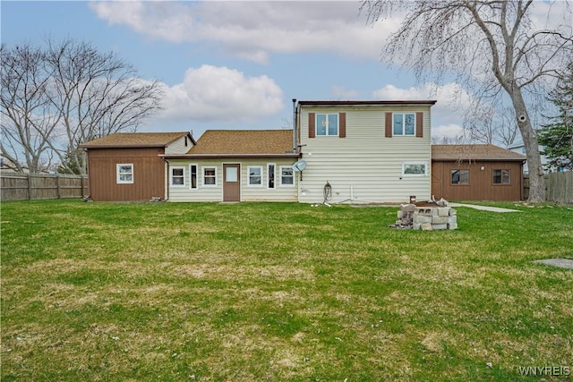 back of house with fence, a yard, and an outdoor fire pit