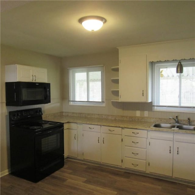 kitchen with dark wood-style floors, a sink, black appliances, white cabinetry, and light countertops