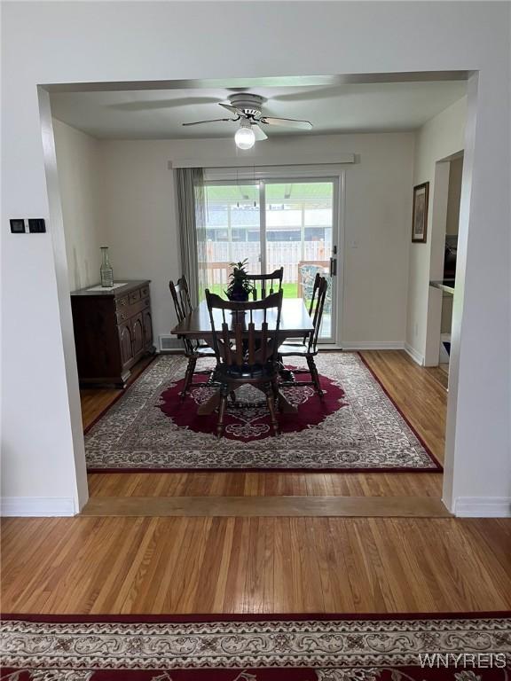 dining space featuring visible vents, baseboards, wood finished floors, and ceiling fan
