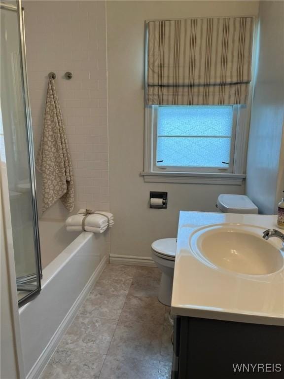 full bathroom with baseboards, vanity, shower / bath combination with glass door, and toilet