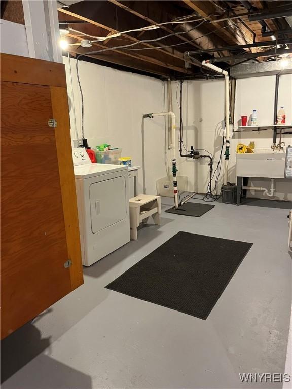 unfinished basement featuring washing machine and dryer and a sink