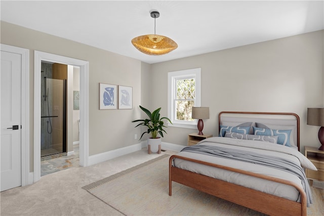 carpeted bedroom with ensuite bath and baseboards