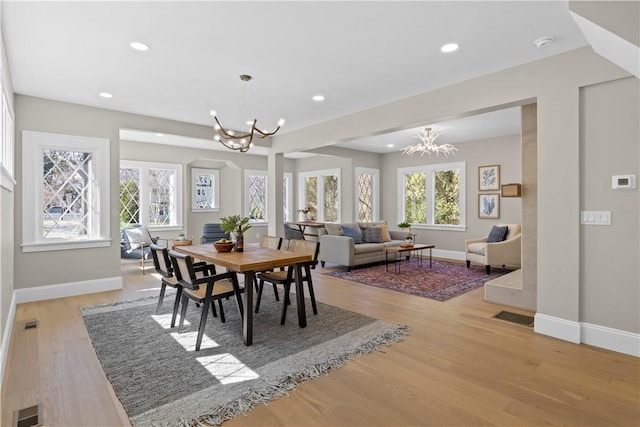 dining space with baseboards, an inviting chandelier, and a wealth of natural light