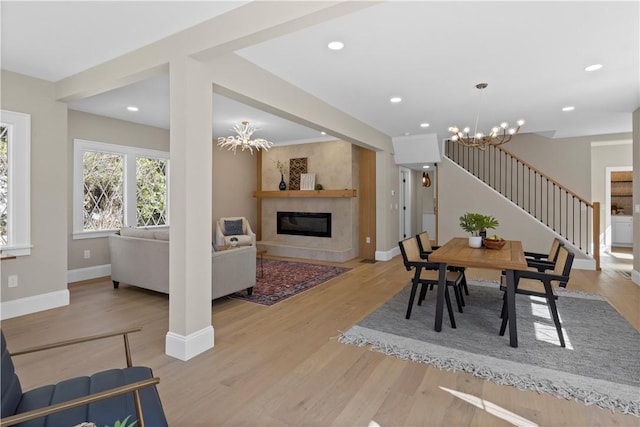 dining room with stairway, a notable chandelier, and light wood finished floors