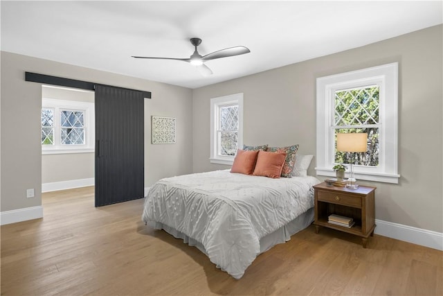 bedroom featuring light wood-type flooring, baseboards, and multiple windows
