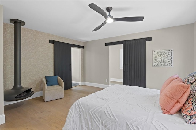 bedroom with wood finished floors, a ceiling fan, and baseboards