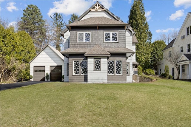 view of front of property featuring roof with shingles, aphalt driveway, and a front yard