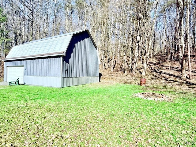 view of outdoor structure with a forest view and an outbuilding