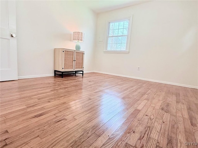 empty room with baseboards and wood finished floors