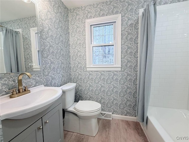 full bathroom featuring wood finished floors, vanity, baseboards, toilet, and visible vents