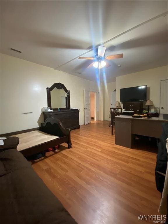 living room featuring wood finished floors, visible vents, and a ceiling fan