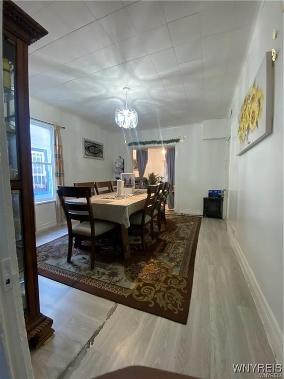 dining area featuring wood finished floors, baseboards, and a notable chandelier