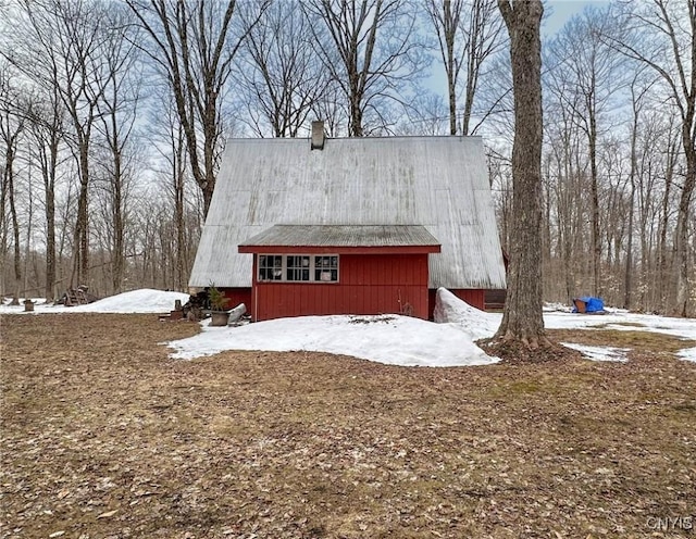 snow covered property with a chimney