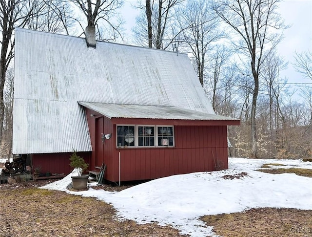 snow covered structure featuring an outbuilding