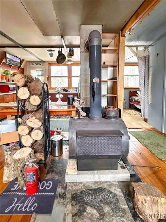 interior space with a wood stove and wood finished floors