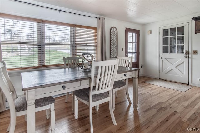 dining room featuring light wood-type flooring and baseboards