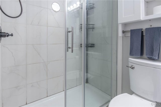 full bathroom featuring a stall shower and toilet