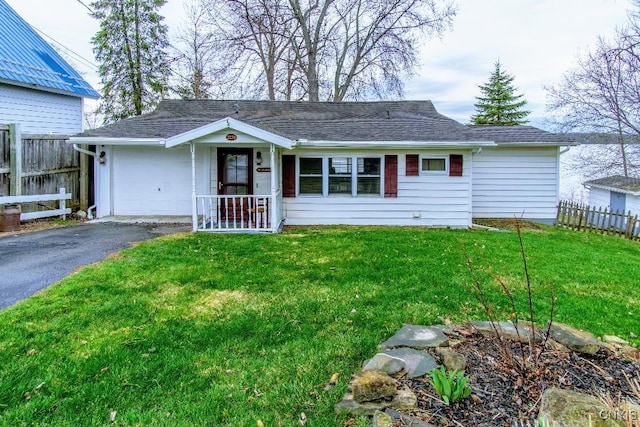 single story home with a shingled roof, fence, driveway, and a front yard